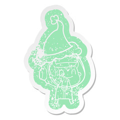 happy cartoon distressed sticker of a astronaut wearing santa hat