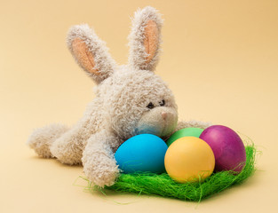 Easter decoration with cute plush rabbit, eggs and grass