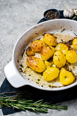 Naklejka na ściany i meble Fried potatoes with garlic, thyme, rosemary and garlic. Grey background, top view