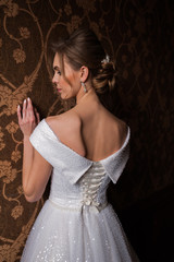 Bride.Young fashion model with perfect skin and make up  brown background  curly hair