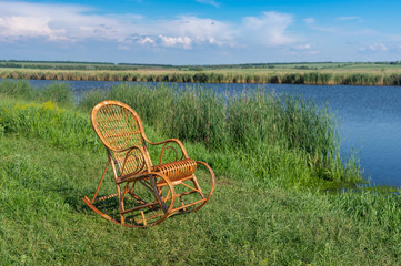 Empty wicker rocking-chair on a Sura riverside waiting for any human to relax
