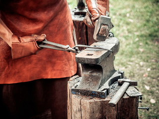 The blacksmith in the production process of metal products handmade on the openair workshop....