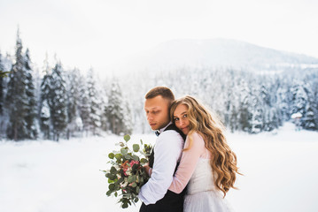 Boy and girl in the winter forest. Wedding in winter.  Hug love couple