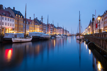 Fototapeta na wymiar morning lights in blue twilight on canal Nyhavn in Copenhagen in Denmark 