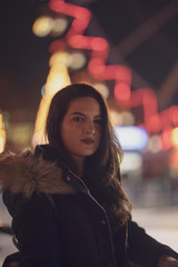 woman in black dress on street of city at night