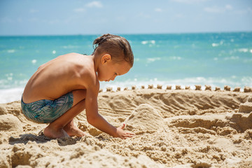 little boy built a sand castle 