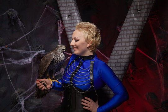 beautiful scary woman with the big hawk best friend on the background of dark room