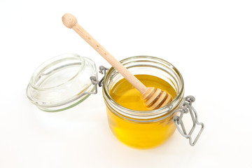 Honey jar with a wooden stick for honey on white background. Concept of healty food. Honey like superfood. Minimalism slyle