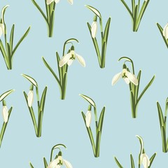 Seamless pattern with white snowdrop flowers and green leaves on a blue background.