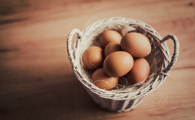  Fresh eggs in wicker basket  on wood table Prepare chicken eggs and egg whisk for cooking or bakery can use for background or wallpaper.