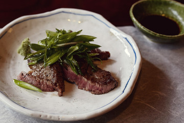 Course of Wagyu beef with scallions and wasabi.  One part of a multi-course, traditional Kaiseki meal in Kyoto, Japan.