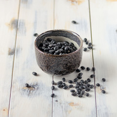 Black mung beans in a bowl on a wooden table