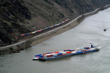 Containerschiff auf dem Rhein und Containerzug auf der Bahnstrecke im Mittelrheintal - Stockfoto