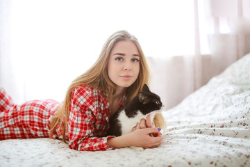 Caucasian girl in pajamas long hair with cat bed