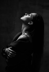 Obraz premium Zamyka w górę portreta młoda piękna kobieta z głową up pozuje modlenie w seksownej wiosny kurtce i bieliźnie