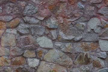 brown stone texture of large cobblestones in the wall of the fence
