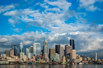 Fototapeta na wymiar Beautiful Sunny Day in Seattle, Washington. The Seattle skyline as seen from the Bainbridge Island ferry. Puffy clouds and blue sky make for a perfect day in the Puget Sound area.
