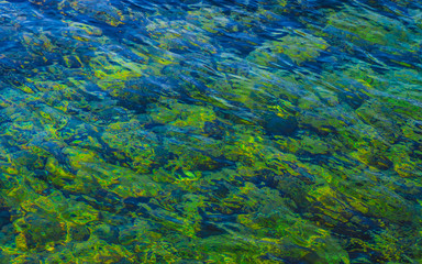 Fototapeta na wymiar Beautiful green water ripples - shallow water texture