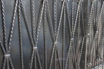 gray black metal background from iron rods in forged pattern