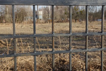 part of a black metal fence made of iron rods