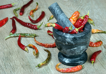 chili pepper in a mortar. chopping red chili pepper in a mortar. top view
