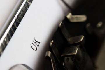 Old soviet typewriter close up. Filled in it blank sheet of paper with the word OK. Macro.