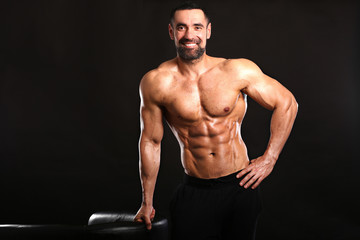 Fototapeta na wymiar Porter of young muscular man on black background show him body , bodybuilding ,sport 