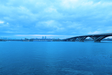 View of the river and bridge away in cloudy weather in nature.