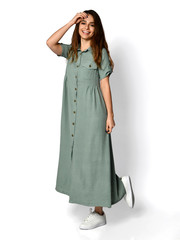 Young beautiful woman posing in new light green fashion dress on high hills full body on a white