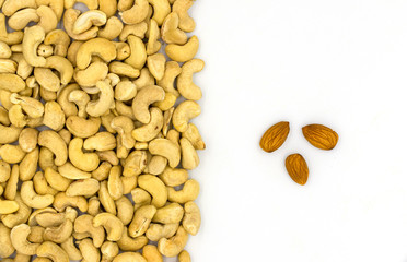 Cashew and almond nuts on white background, top view photo. Scattered nut on table. Organic food rustic banner template