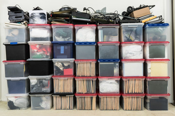 Tall wall of plastic file storage boxes with folders, binders and miscellaneous business office...