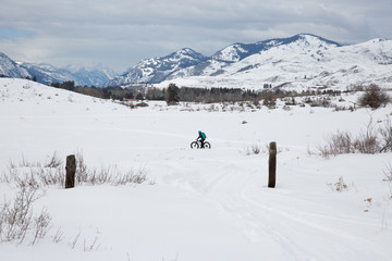 Fototapeta na wymiar Woman riding fat bike in snowy mountains