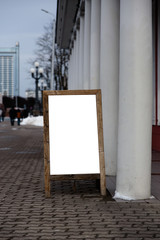 Blank ad space on a wooden stand in the street outside
