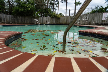 Dirty pool sits unattended covered in leaves