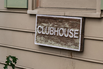 Wooden Clubhouse sign mounted on the outside of apartment building