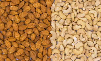 Cashew and almond nut texture on white background, top view photo. Scattered nut on table. Organic food