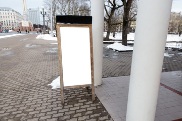 Blank ad space on a wooden stand in the street outside