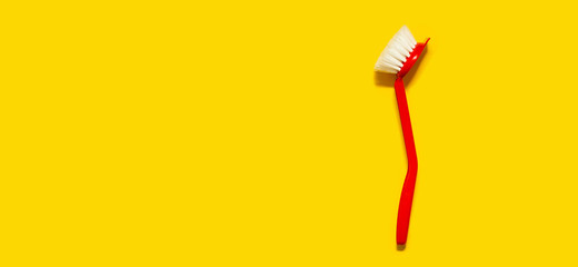 Bright red brush lies on a bright yellow background. In the style of pop art. Top view. Copy space.