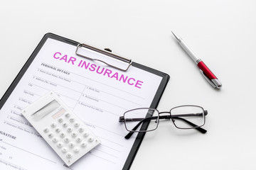 Car insurance form near glasses, calculator, pen on white background