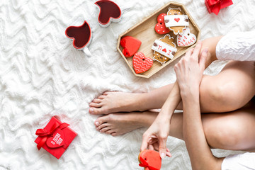 Girl in love with present, heart-shaped cookies and mag for St Valentine Day celebration top view...