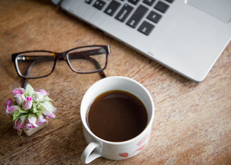  laptop sitting on table with coffee, glasses and plant. good for writer, author or digital nomad concept. 