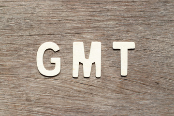 Alphabet letter in word GMT (abbreviation of Greenwich Mean Time) on wood background