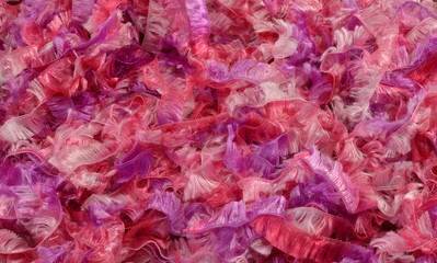 Close up of strands of fluffy pink and purple yarn or ribbon
