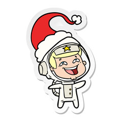 Fototapeta premium sticker cartoon of a laughing astronaut wearing santa hat