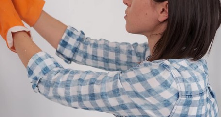 Young woman painting interior of wall of her new house