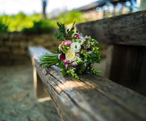 The bride's bouquet lying on an old wooden log