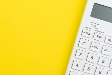 Mathematics, tax calculation, finance or investment concept, white clean calculator on solid yellow...