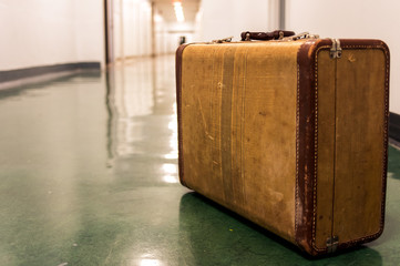 Old vintage suitcase on a airport terminal corridor