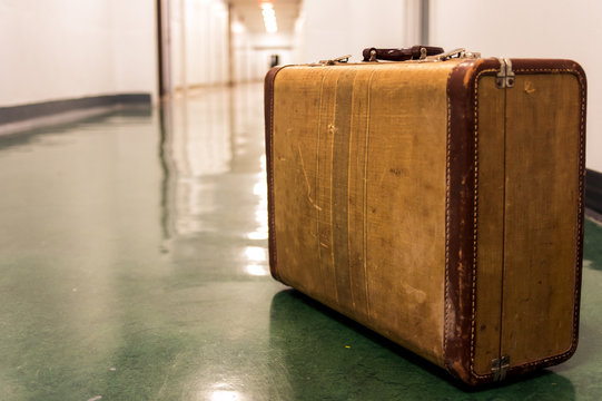 Old vintage suitcase on a airport terminal corridor