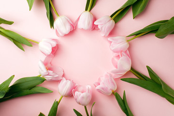 Pastel pink tulip flowers bouquet round border on pink background. Flat lay, top view. Minimal floral springtime flatlay concept